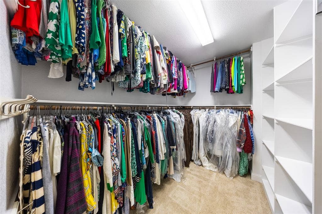 Walk-in closet In Primary Bedroom, featuring built-in shelving, multiple system, and recessed overhead lighting