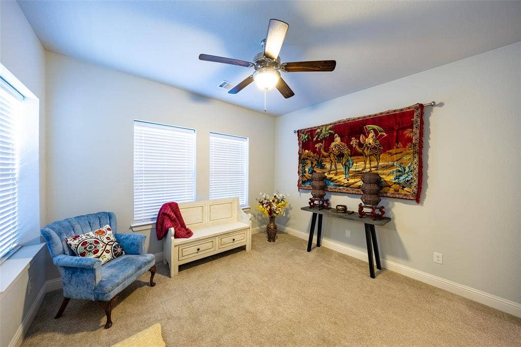 Yoga or guest room with numerous windows and ceiling fan.