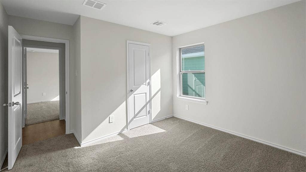 1953 Freeman Street, Tyler, TX 75704 Light-filled room featuring neutral wall paint, gray carpeting, a double-hung window, and white trim