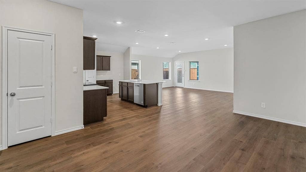 1953 Freeman Street, Tyler, TX 75704 Spacious open-concept living area featuring wood-finish flooring, recessed lighting, and a kitchen island with built-in cabinetry and an integrated dishwasher