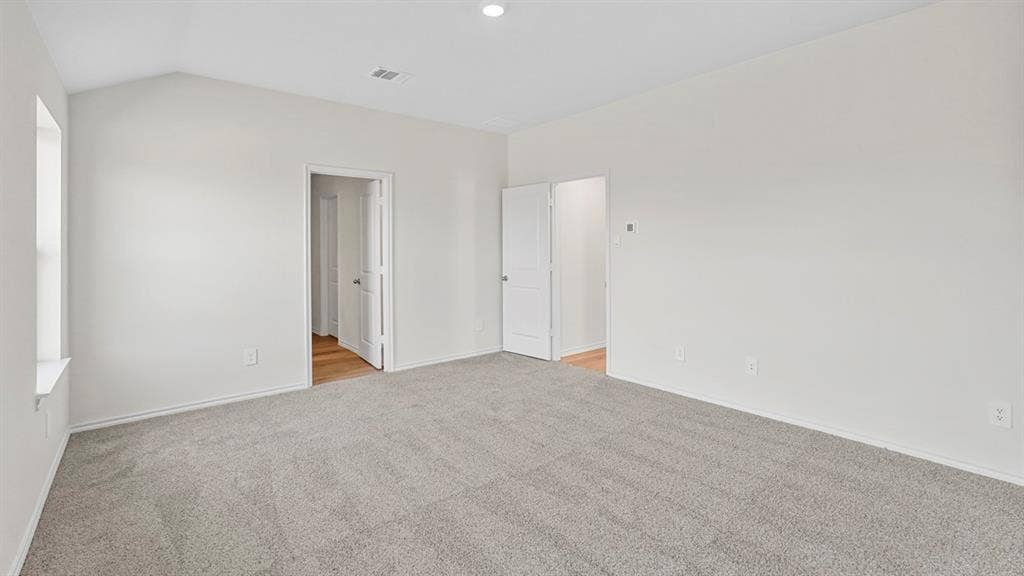 1953 Freeman Street, Tyler, TX 75704 Spacious room featuring gray carpeting, white walls, and a vaulted ceiling with a recessed light fixture