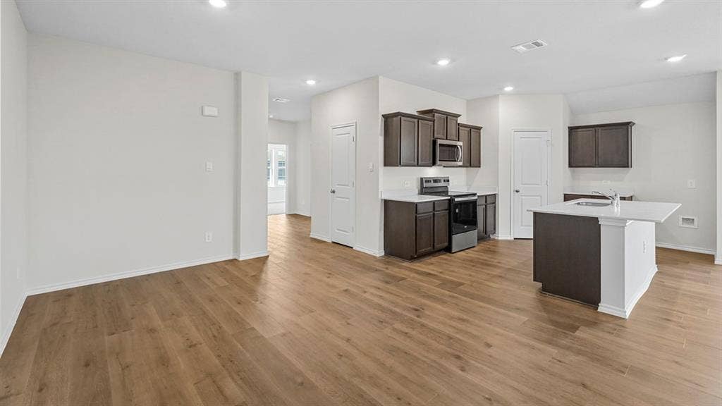 1953 Freeman Street, Tyler, TX 75704 Spacious open-concept living area featuring wood-finish flooring, recessed lighting, and a kitchen island with a white countertop