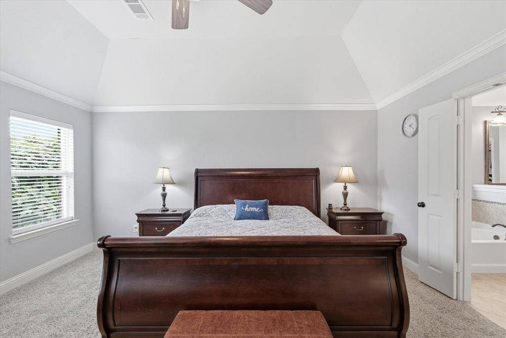 Carpeted room featuring a vaulted ceiling and crown molding