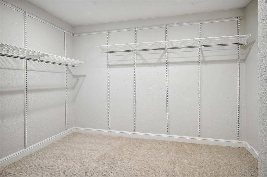 13430 Challaburton Drive, Farmers Branch, TX 75234 Main bedroom closet, 8x10 Walk-in featuring adjustable wire shelving, integrated hanging rods, plush carpet flooring, and white baseboard trim