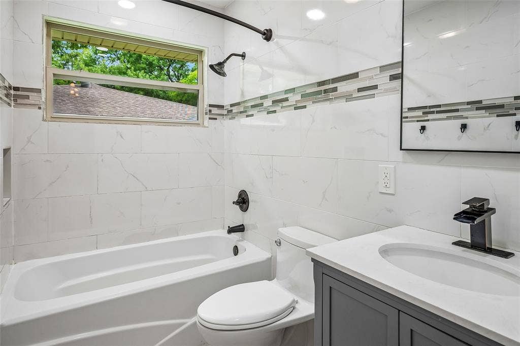 13430 Challaburton Drive, Farmers Branch, TX 75234 Modern bathroom featuring white tile walls with a decorative mosaic accent band