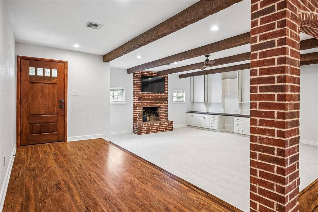13430 Challaburton Drive, Farmers Branch, TX 75234 BVIRTUAL STAGING edroom featuring a rustic wood barn door, hardwood flooring, ceiling fan, and a window with horizontal blinds