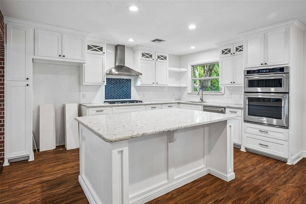 13430 Challaburton Drive, Farmers Branch, TX 75234 Bright living area featuring exposed wood beams, a brick fireplace, built-in cabinetry, recessed lighting, and a wood-panel accent wall