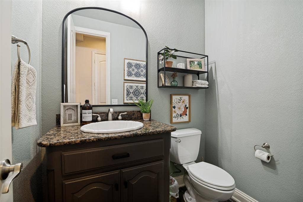 4305 Loch Haven Court, McKinney, TX 75072 Bathroom vanity featuring a granite countertop, white oval sink, and dark wood-finish cabinetry