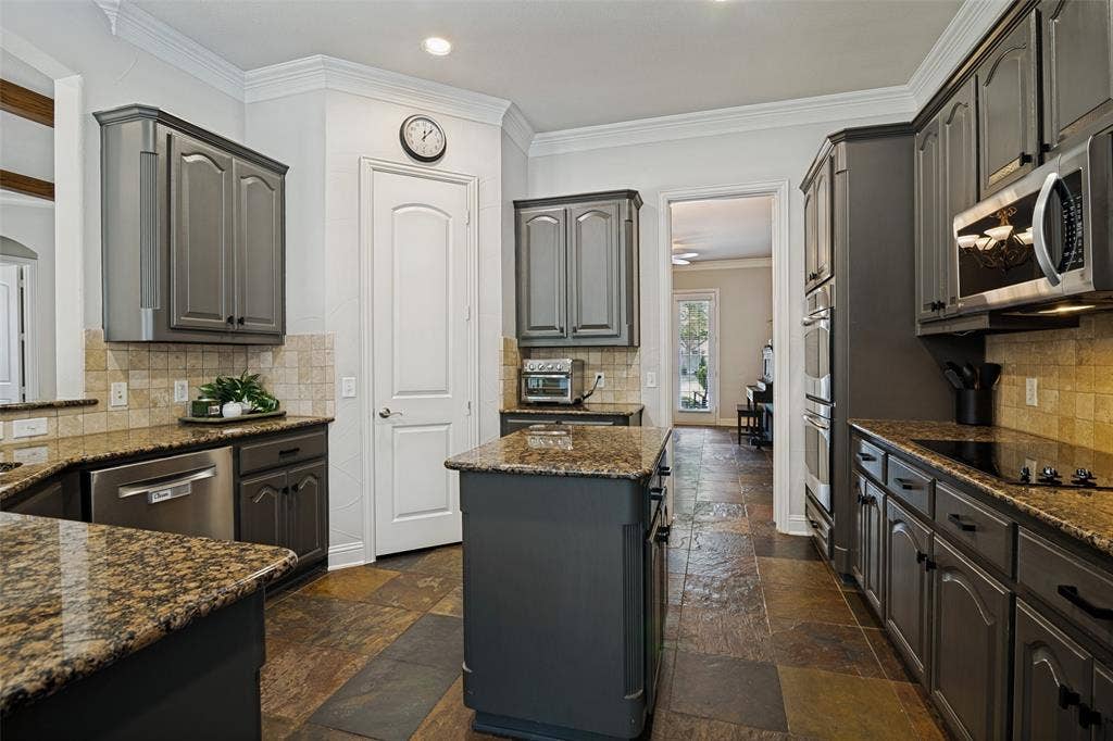 4305 Loch Haven Court, McKinney, TX 75072 Kitchen featuring dark wood-finish cabinetry, granite countertops, and stone tile flooring