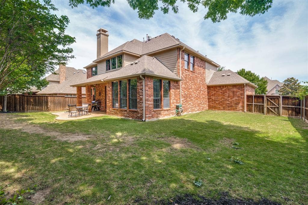 4305 Loch Haven Court, McKinney, TX 75072 Rear brick and siding exterior featuring a covered patio, bay windows, and a fenced yard with mature trees