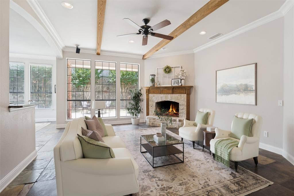 4305 Loch Haven Court, McKinney, TX 75072 Virtually staged. Spacious living area featuring a stone-clad fireplace with a wood mantle, exposed wood ceiling beams, and recessed lighting