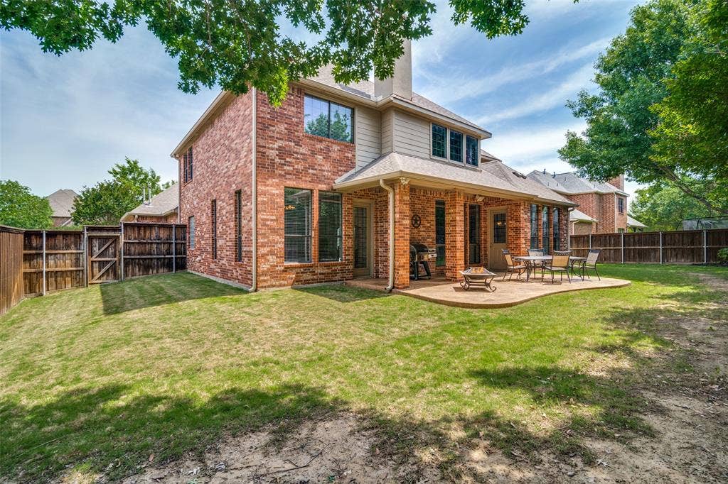 4305 Loch Haven Court, McKinney, TX 75072 Brick exterior featuring a covered patio, shaped concrete hardscape, and a fenced backyard
