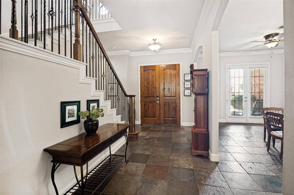 4305 Loch Haven Court, McKinney, TX 75072 Entryway featuring slate tile flooring, wood double entry doors, a grand staircase with wrought iron balusters, and crown molding