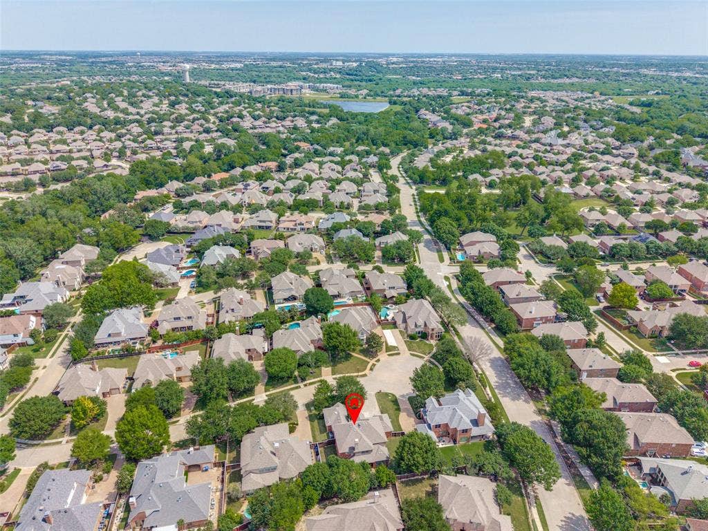4305 Loch Haven Court, McKinney, TX 75072 Aerial perspective of a residential neighborhood with numerous single-family homes, mature trees, and a distant body of water