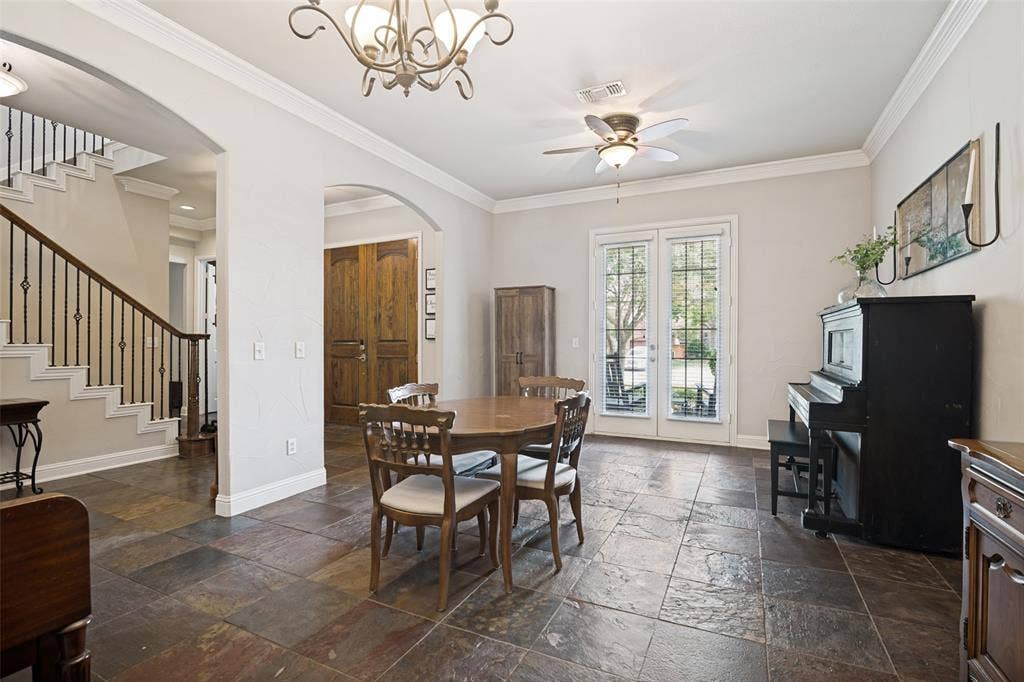 4305 Loch Haven Court, McKinney, TX 75072 Spacious room featuring multi-toned stone tile flooring, crown molding, and a chandelier lighting fixture