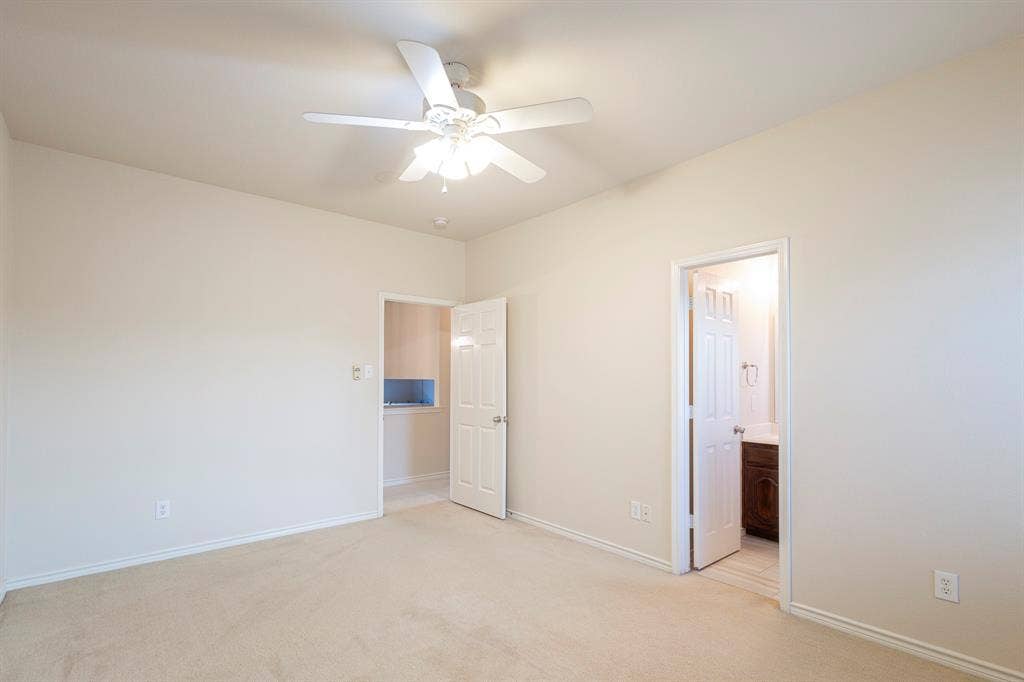 1200 Talley Lane, Frisco, TX 75033 Unfurnished bedroom with light carpet, connected bathroom, and ceiling fan