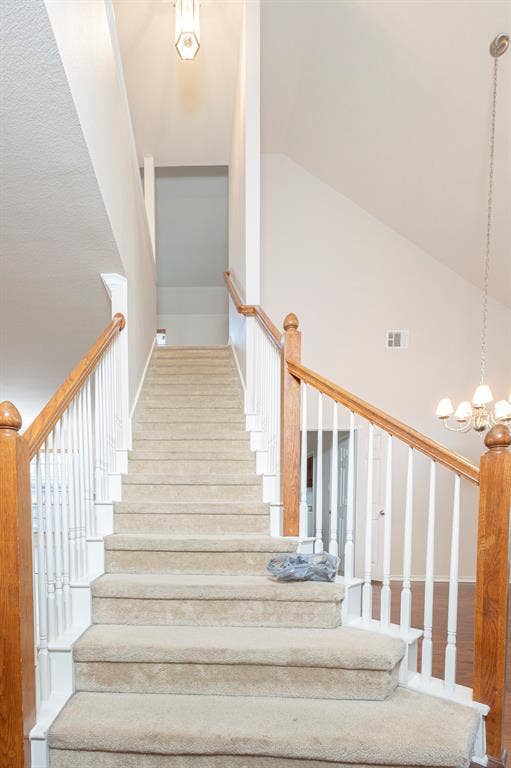 1200 Talley Lane, Frisco, TX 75033 Stairway featuring high vaulted ceiling, an inviting chandelier, and wood-type flooring
