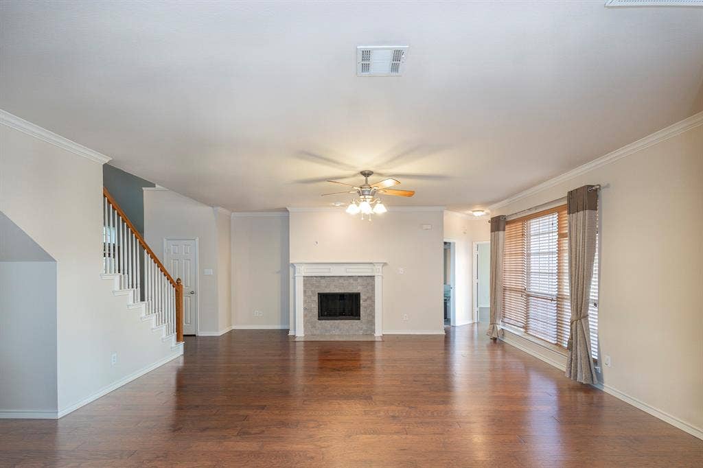 1200 Talley Lane, Frisco, TX 75033 Unfurnished living room featuring ceiling fan, dark hardwood / wood-style flooring, and crown molding