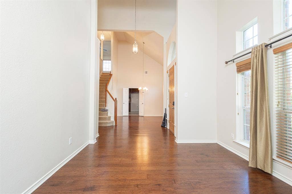 1200 Talley Lane, Frisco, TX 75033 Hallway with high vaulted ceiling and dark hardwood / wood-style floors