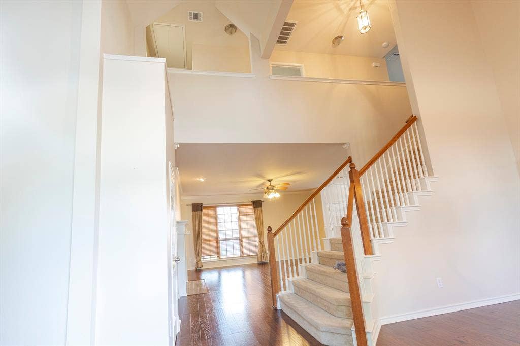 1200 Talley Lane, Frisco, TX 75033 Stairway featuring a high ceiling, ceiling fan, and dark wood-type flooring