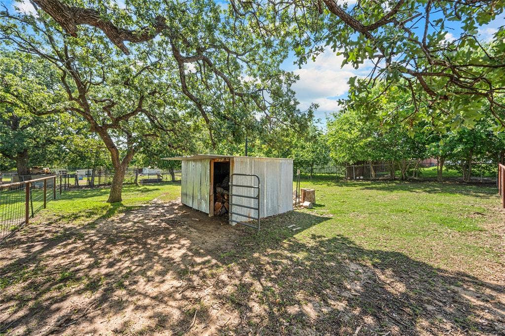 5656 Oak Haven Drive, Fort Worth, TX 76244 The fenced-off pasture and small shed are ready for goats, chickens, or a fun little homestead setup.