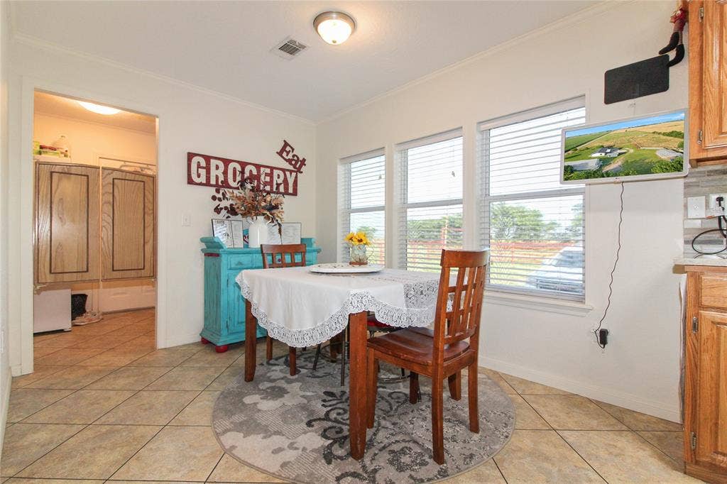 455 Hughes Cemetery Road, Italy, TX 76651 Dining area with three large windows, tile flooring, and a flush-mount ceiling light