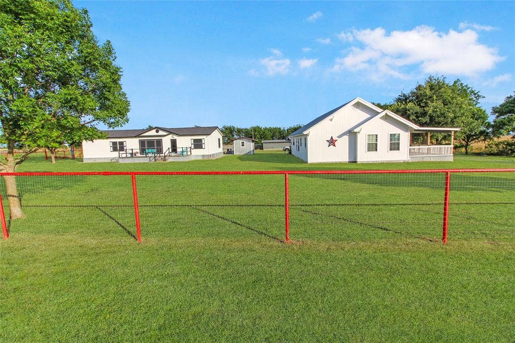 455 Hughes Cemetery Road, Italy, TX 76651 Expansive green lawn with a red-framed wire fence