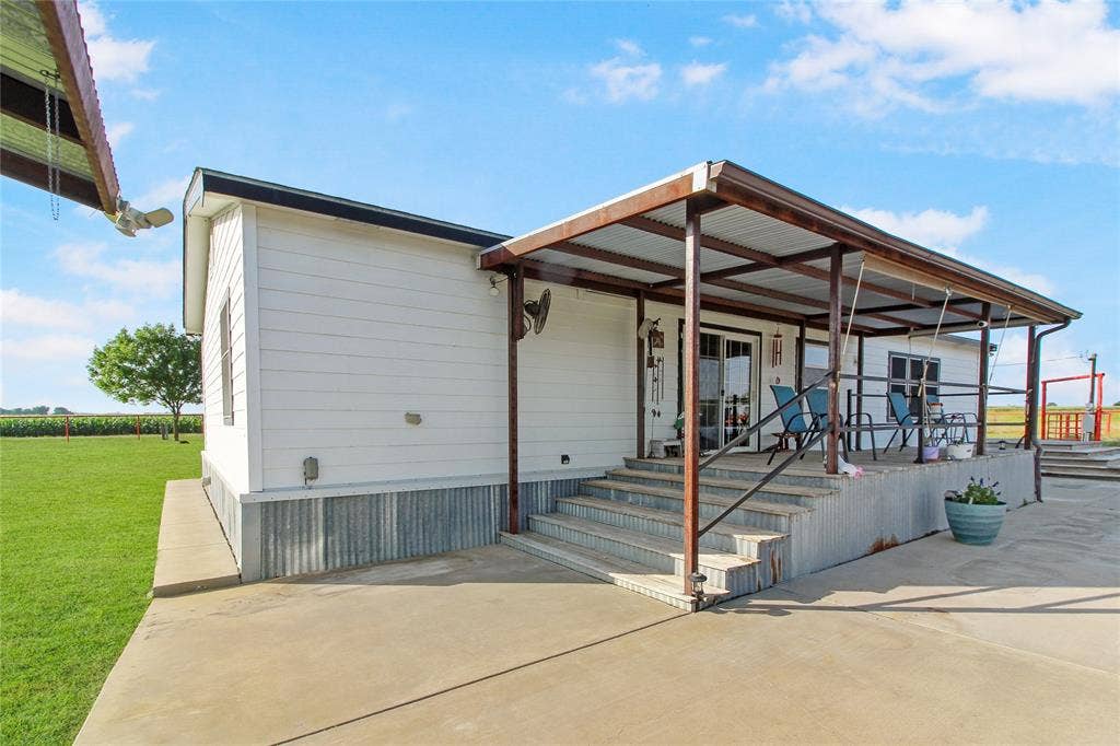 455 Hughes Cemetery Road, Italy, TX 76651 Expansive covered patio with concrete flooring, metal framing, and a corrugated metal roof
