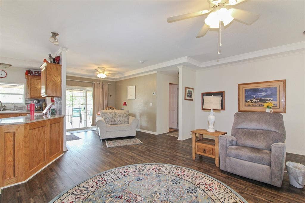 455 Hughes Cemetery Road, Italy, TX 76651 Spacious living area featuring wood-finish flooring, crown molding, and multiple ceiling fans