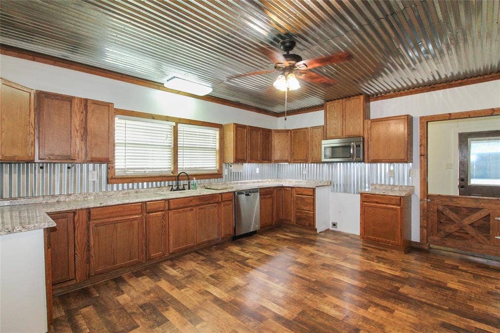 455 Hughes Cemetery Road, Italy, TX 76651 1936 HOUSE Kitchen featuring wood-finish flooring, oak cabinetry, and granite-style countertops