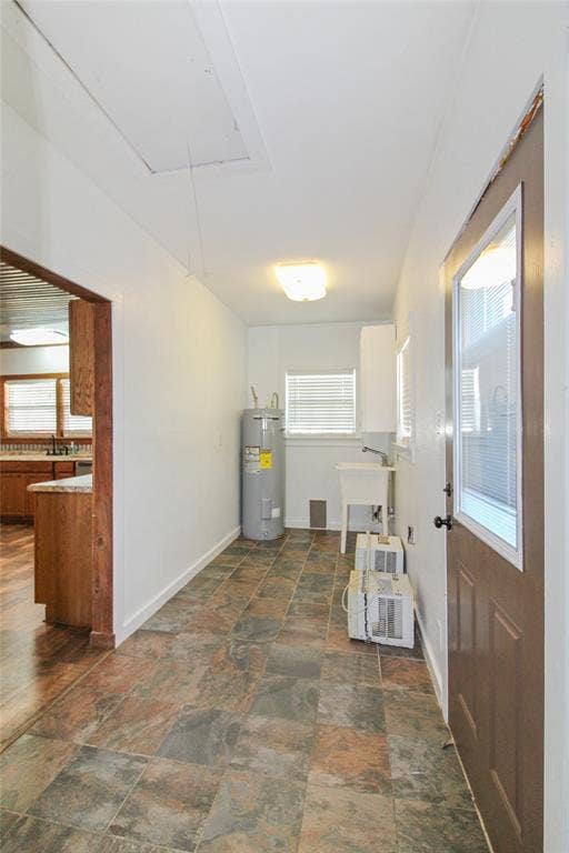 455 Hughes Cemetery Road, Italy, TX 76651 1936 HOUSE Utility area featuring a water heater, utility sink, and tiled flooring