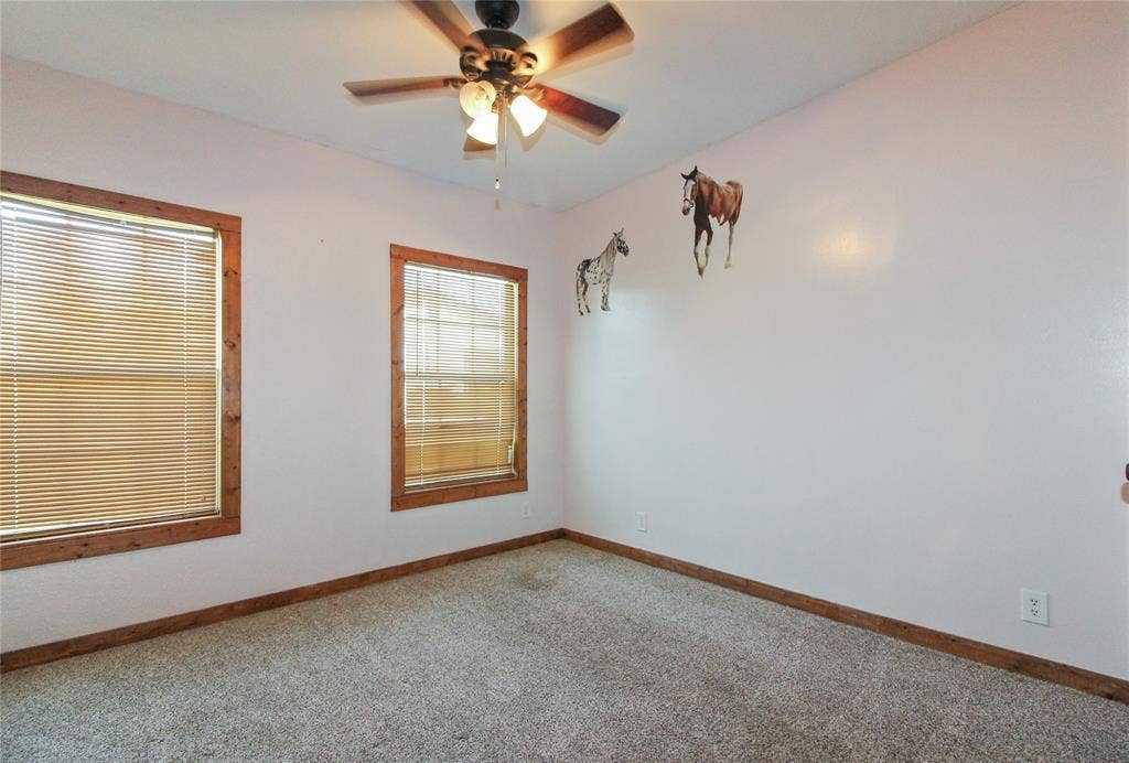 455 Hughes Cemetery Road, Italy, TX 76651 1936 HOUSE Carpeted room featuring dual windows with wood-finish trim and blinds