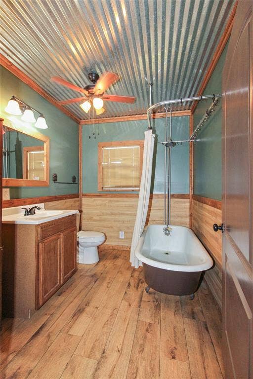 455 Hughes Cemetery Road, Italy, TX 76651 1936 HOUSE Bathroom featuring a corrugated metal ceiling, wood-finish flooring, and wood paneling on walls