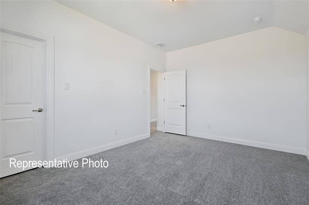 Spacious room featuring light gray carpeting and bright white walls