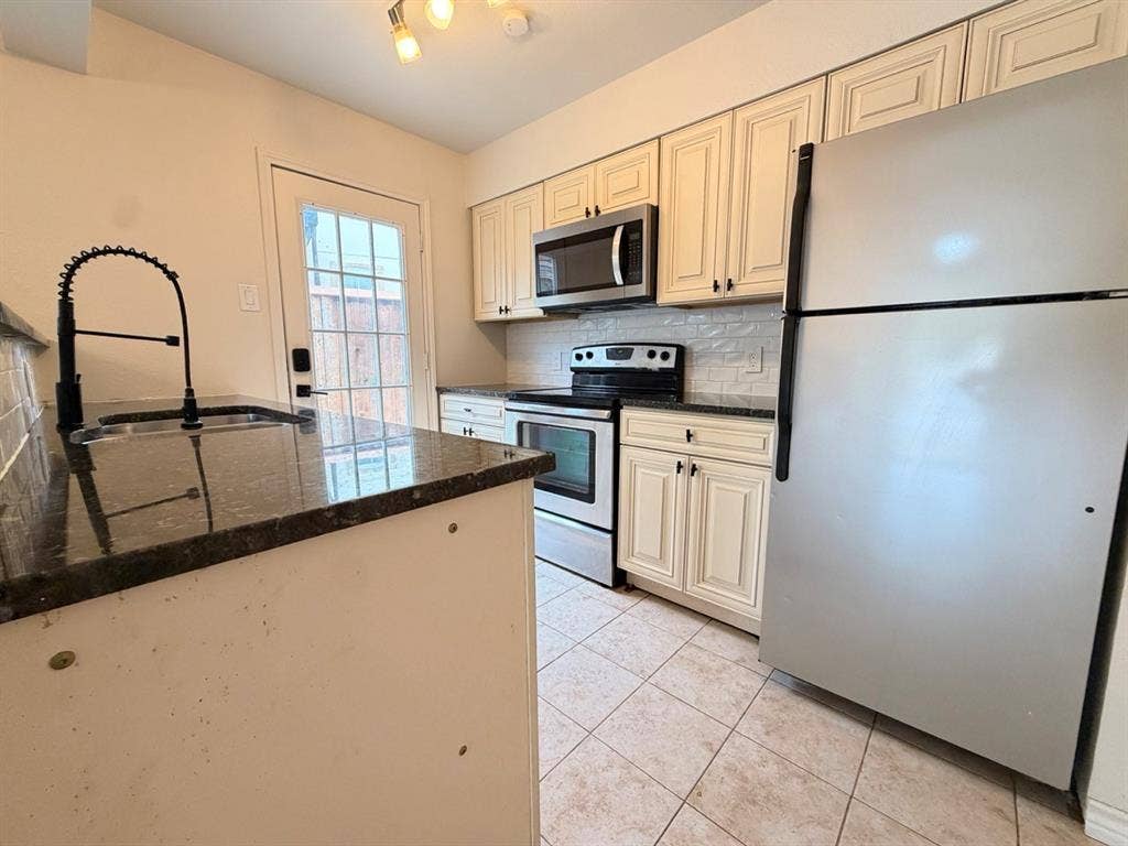 14003 Brookgreen Drive, Dallas, TX 75240 Kitchen featuring a stainless steel refrigerator, microwave, and range