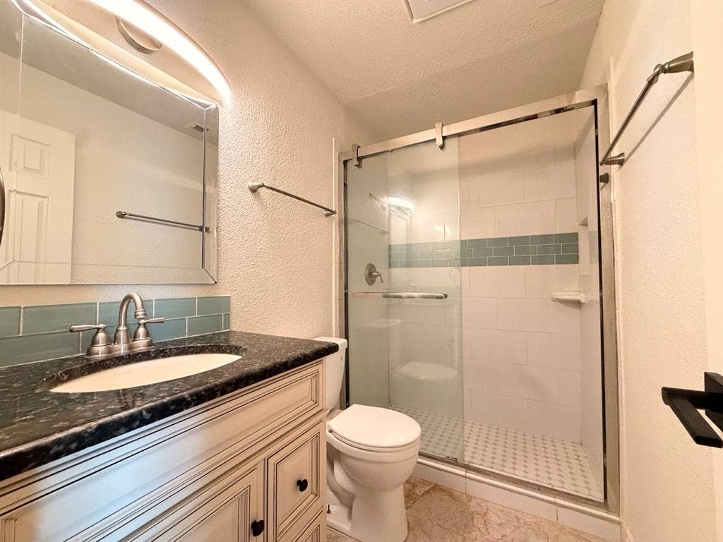 14003 Brookgreen Drive, Dallas, TX 75240 Bathroom vanity with a dark speckled countertop and undermount sink