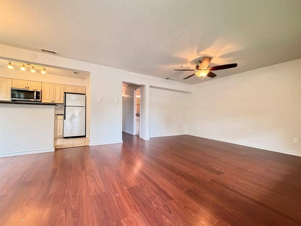 14003 Brookgreen Drive, Dallas, TX 75240 Open-concept living area featuring wood-finish flooring, a ceiling fan with integrated lighting, and white baseboards