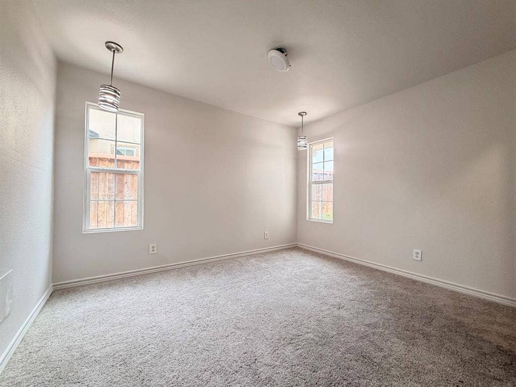 14003 Brookgreen Drive, Dallas, TX 75240 Spacious room featuring neutral-toned walls, plush grey carpeting, and two large windows providing ample natural light