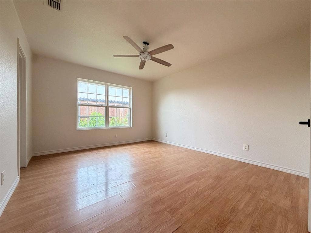 14003 Brookgreen Drive, Dallas, TX 75240 Spacious room featuring wood-finish flooring, a multi-pane window, and a ceiling fan