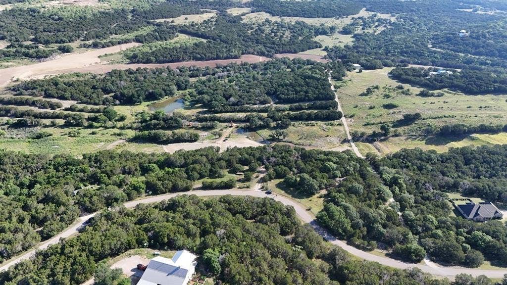 Expansive rural landscape featuring a winding road and verdant tree coverage