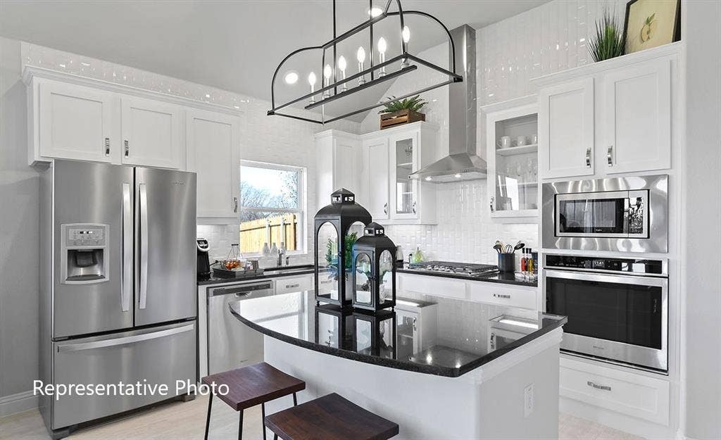 1140 Beaumont Lane, Red Oak, TX 75154 Kitchen featuring white cabinetry, stainless steel appliances, a center island with a dark countertop, a tile backsplash, and an overhead light fixture