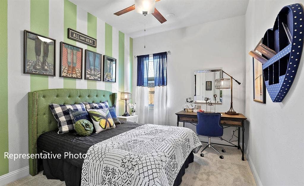 1140 Beaumont Lane, Red Oak, TX 75154 Carpeted room featuring a ceiling fan, a window with sheer and blackout curtains, and a desk with a mirror and task lamp