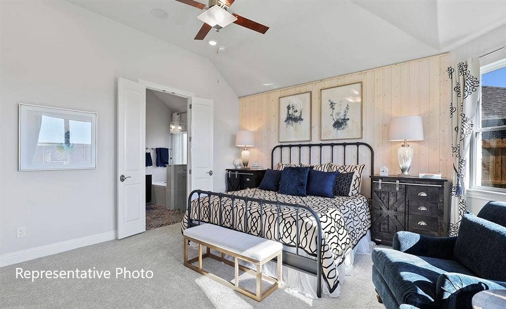 1140 Beaumont Lane, Red Oak, TX 75154 Vaulted ceiling bedroom featuring carpet flooring, shiplap accent wall, ceiling fan, and double doors opening to a bathroom