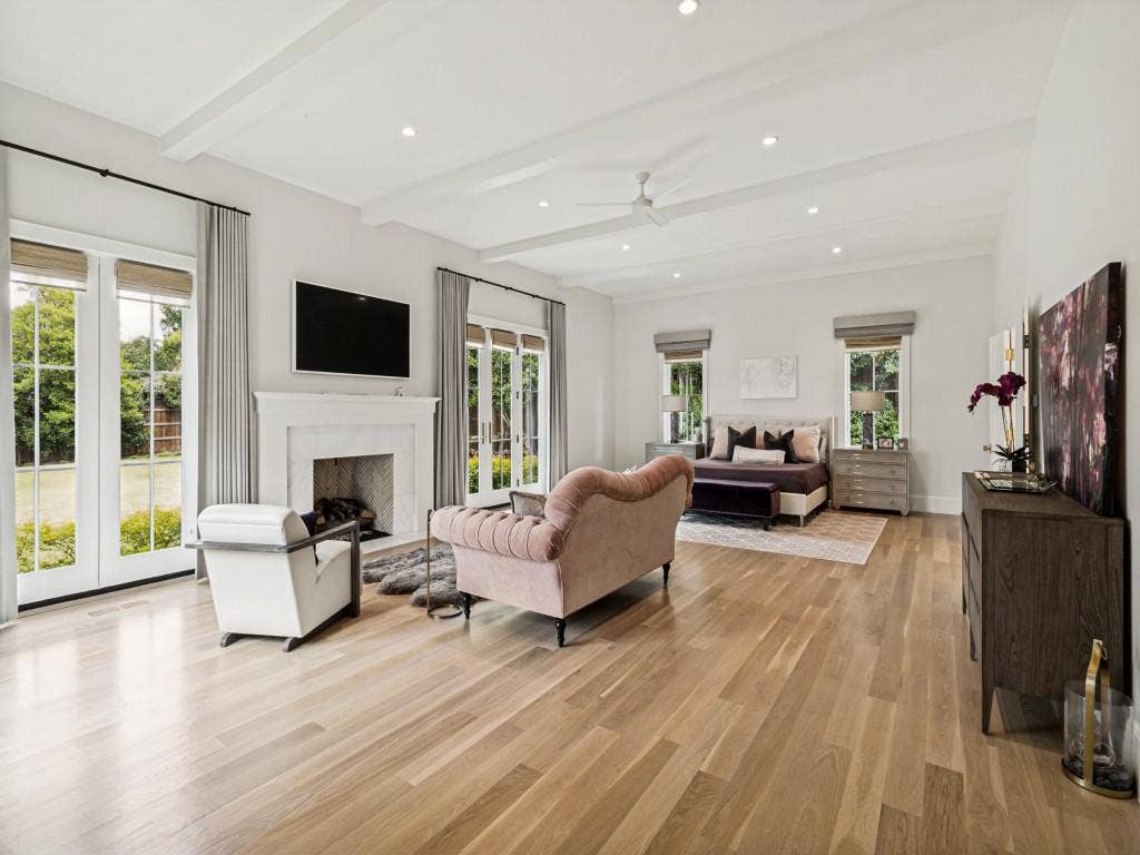 Primary bedroom overlooking backyard, with fireplace and sitting area