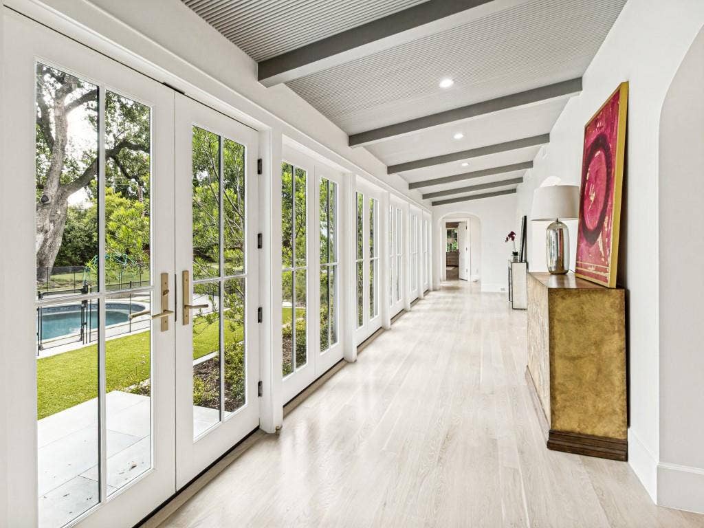Sunroom hallway to primary overlooking pool and backyard