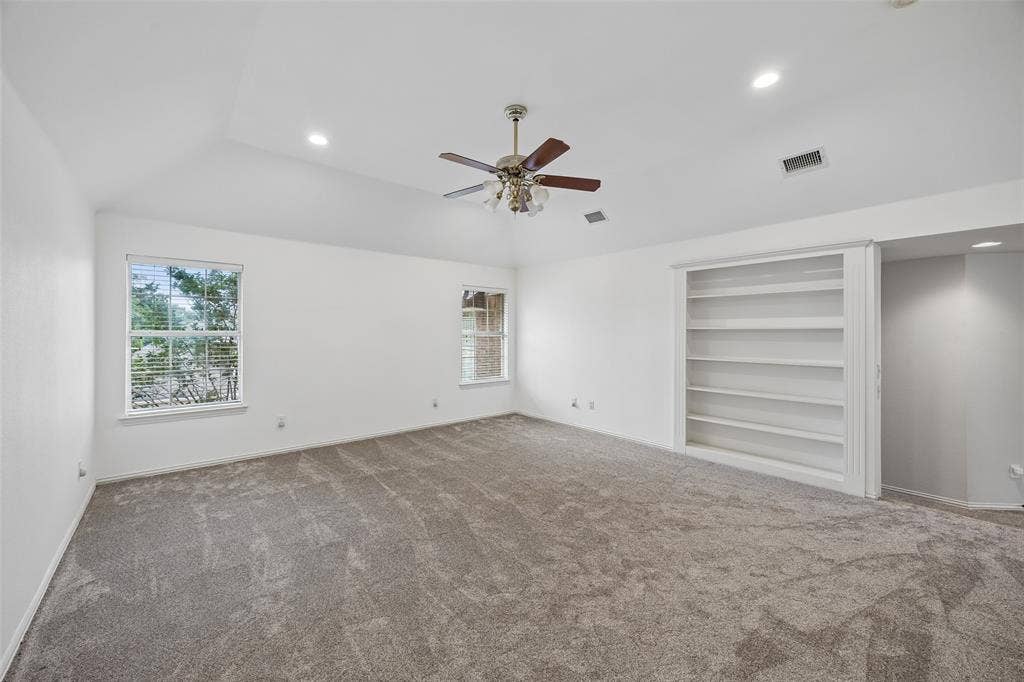 2701 Oates Drive, Plano, TX 75093 Spacious room featuring vaulted ceilings, recessed lighting, neutral-toned carpet, a ceiling fan, and built-in shelving