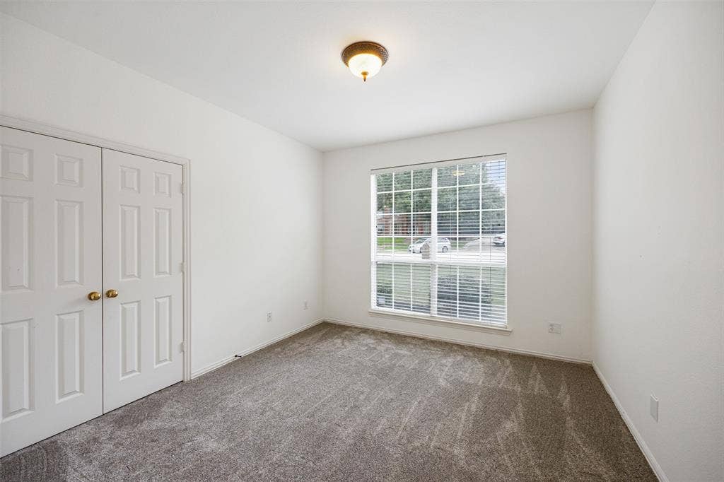 2701 Oates Drive, Plano, TX 75093 Bright interior space featuring a large window , neutral carpeting, and a double-door closet