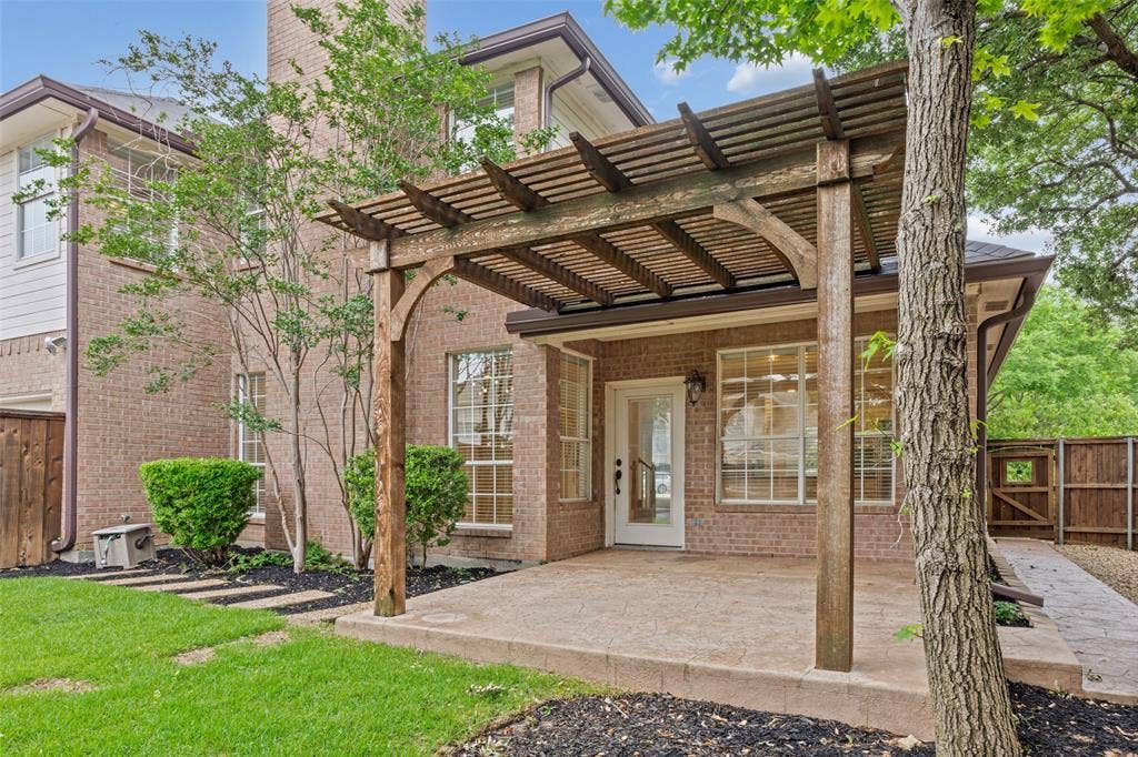 2701 Oates Drive, Plano, TX 75093 Brick exterior featuring a wood pergola over a concrete patio