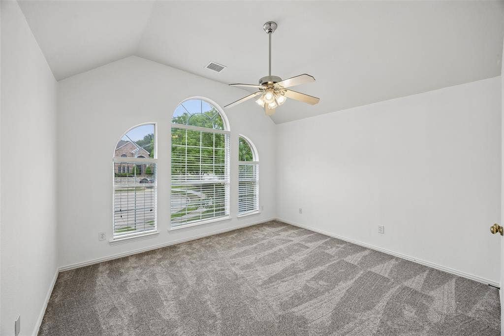 2701 Oates Drive, Plano, TX 75093 Vaulted ceiling room featuring three arched windows, a ceiling fan with integrated lighting, and neutral-toned carpet