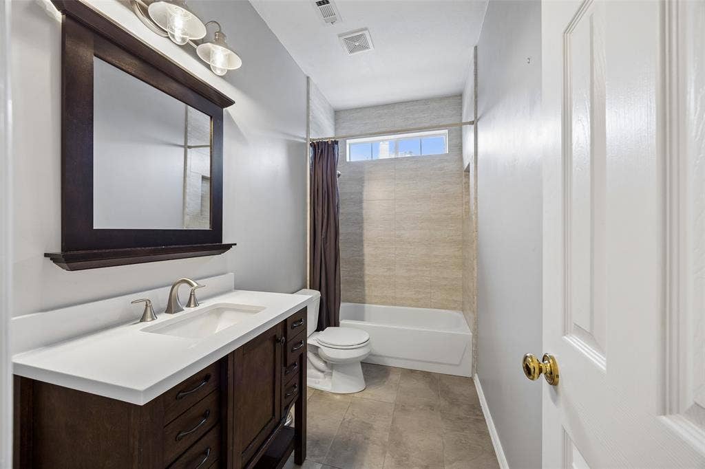 2701 Oates Drive, Plano, TX 75093 Bathroom vanity featuring a white countertop, undermount sink, and brushed nickel faucet